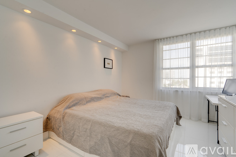 A bedroom with a bed, dresser, and window.