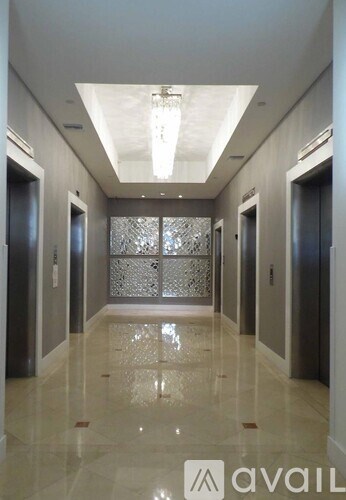 A long hallway with a glass partition on the wall and doors on both sides.
