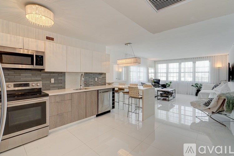 A modern kitchen with stainless steel appliances and a dining area with a glass table.