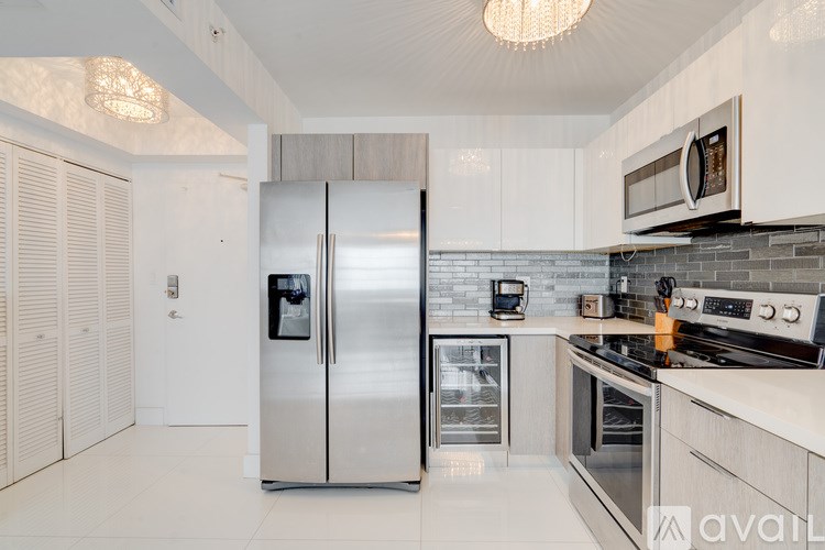 A modern kitchen with a stainless steel refrigerator and a microwave above the stove.