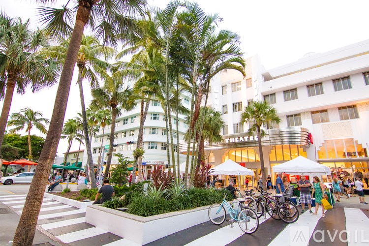 A white building with a sign that says "THEATRE" is behind a white tent.