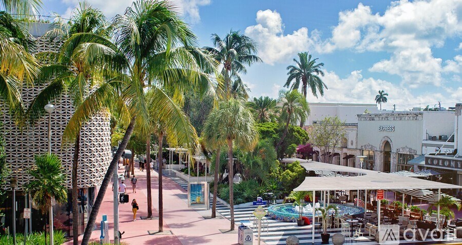 A sunny day at the beach with palm trees and a clear blue sky.
