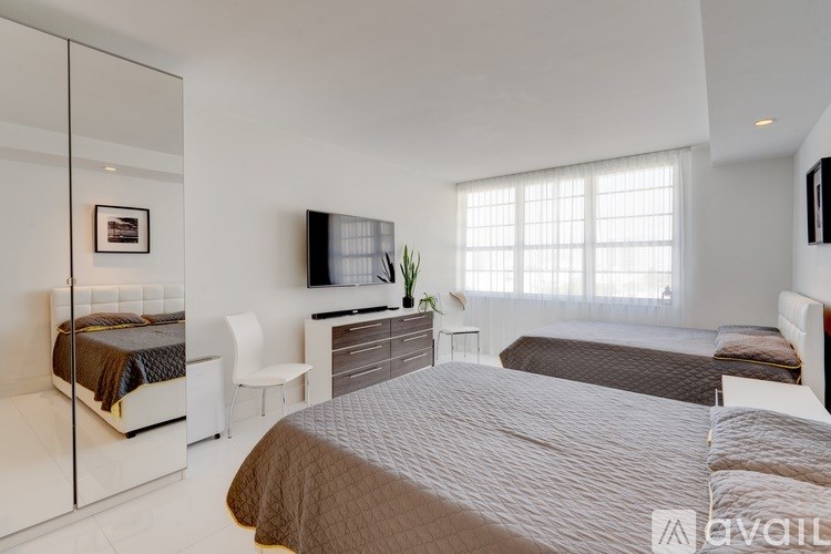 A bedroom with a large bed and a flat screen TV mounted on the wall.