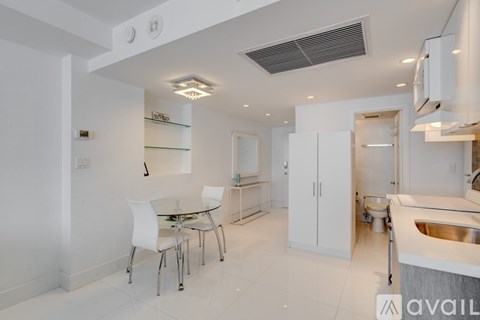 A modern kitchen with a dining table and chairs.