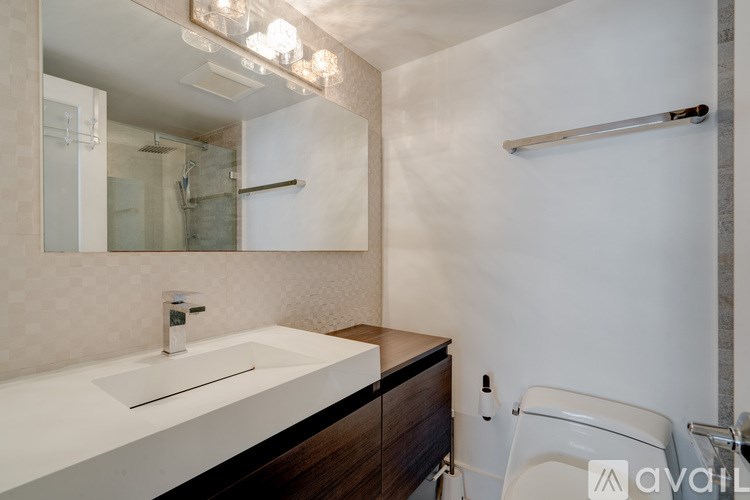 A modern bathroom with a white sink and a white toilet.