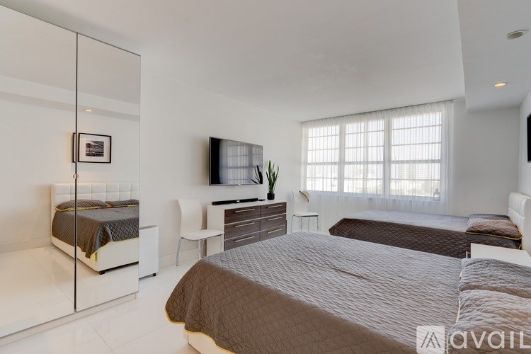 A bedroom with a large bed and a flat screen TV mounted on the wall.