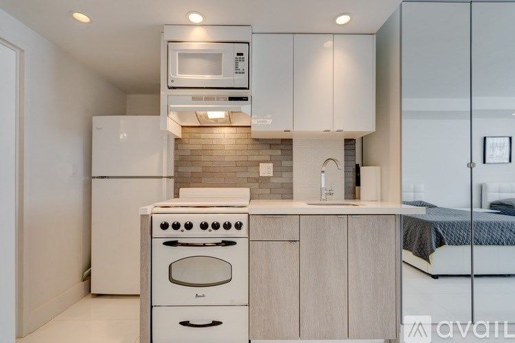 A modern kitchen with white appliances and cabinets.
