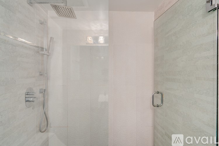 A shower area with a glass door and a shower head.