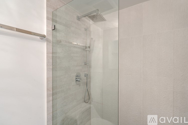 A shower area with a glass door and a shower head.