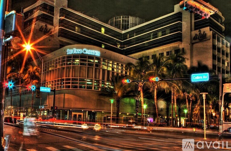 A busy street scene with a large building named "The Ritz-Carlton" in the background.