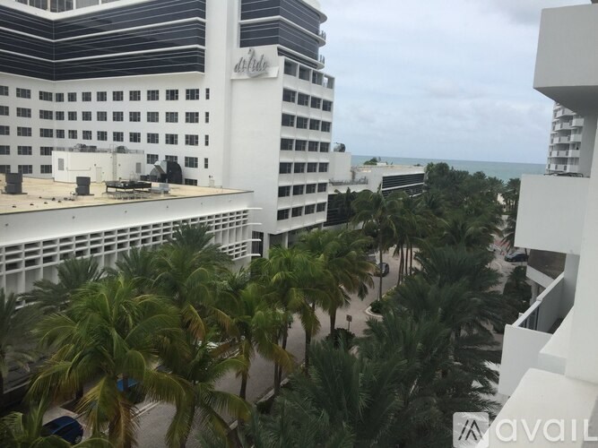 A view of a hotel with palm trees in the foreground.
