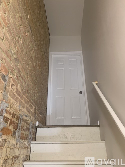 A white door is at the top of a staircase.
