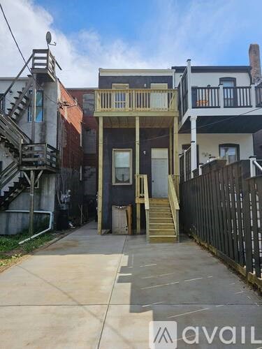A house with a wooden deck and stairs leading to the front door.