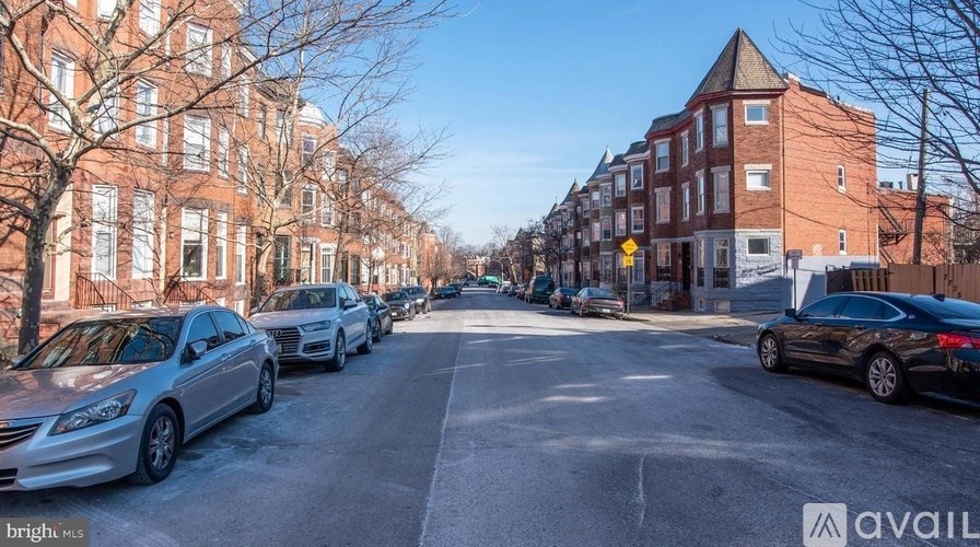 Cars parked on a street with buildings on both sides.