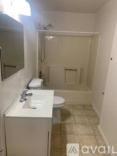 A bathroom with a toilet, sink, and mirror.