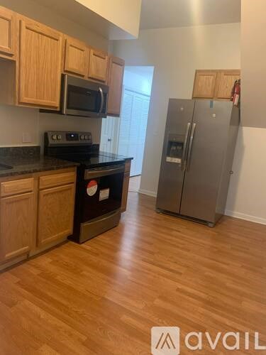 A kitchen with wooden cabinets and a black countertop.