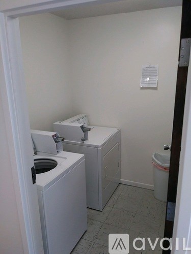 A small bathroom with a toilet, sink, and trash can.