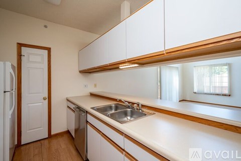A kitchen with white cabinets and a wooden countertop.