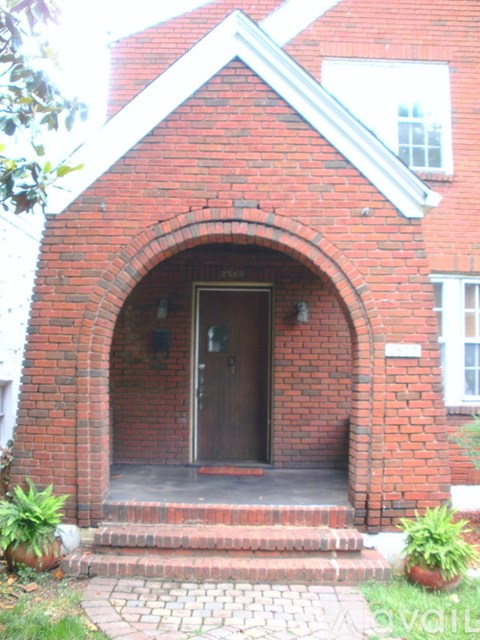 A red brick building with a white trim and a brown door.