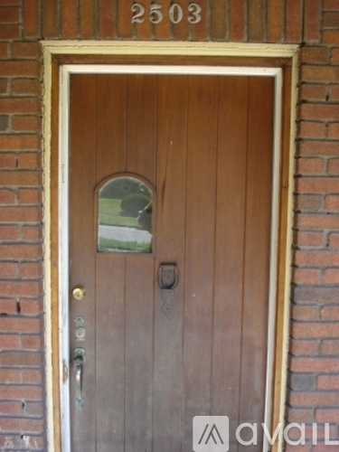A brown door with a glass window and a mail slot.