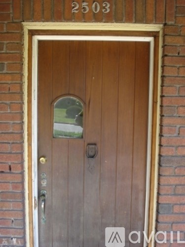 A brown door with a glass window and a mail slot.
