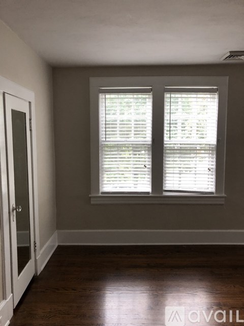 A room with a window and wooden floors.