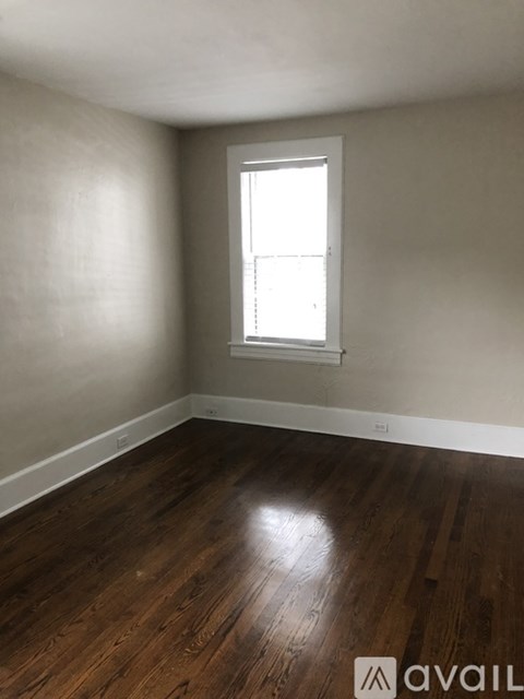 A room with wooden floors and a window letting in light.