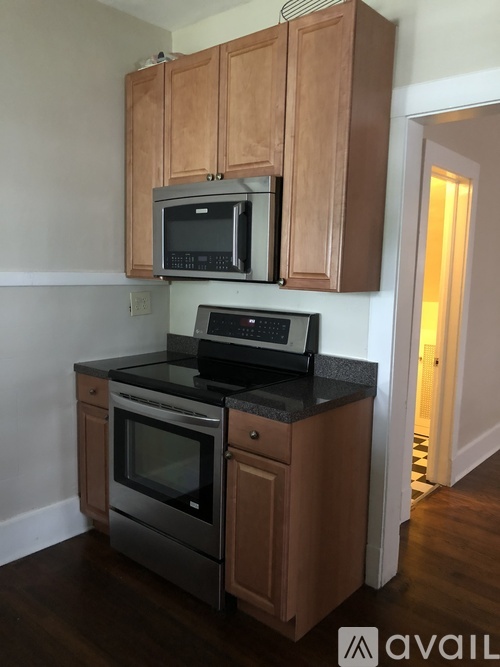 A kitchen with wooden cabinets and black countertops.
