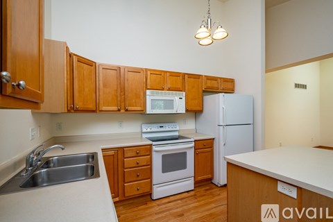 A kitchen with wooden cabinets and a white fridge.