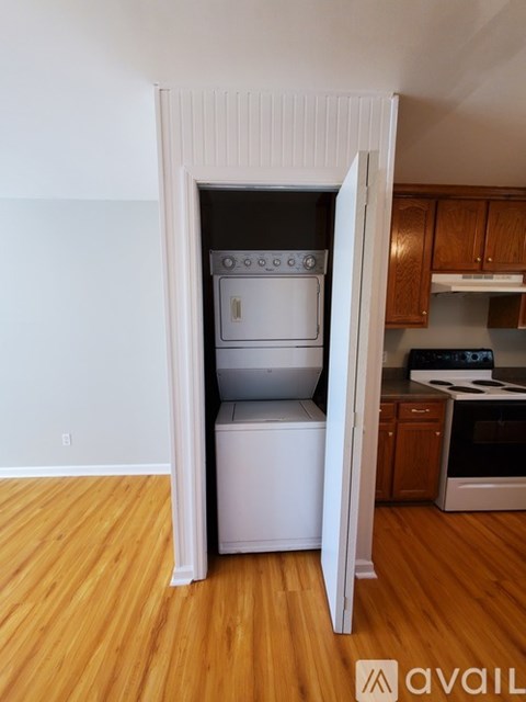 A kitchen with a white oven and dishwasher in a room with wooden floors.