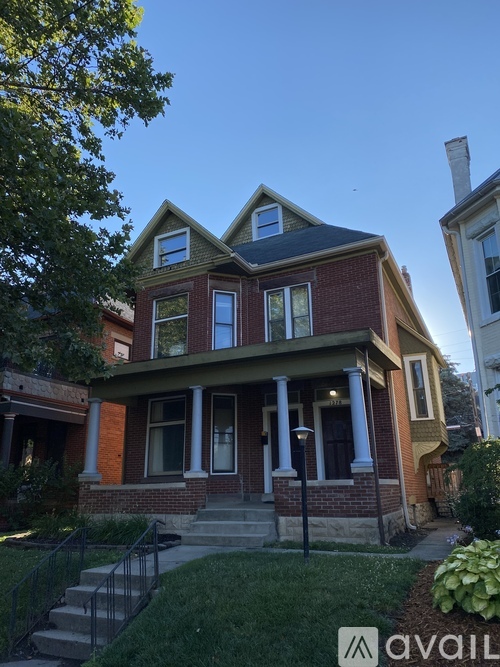 A house with a front porch and a tree in front.