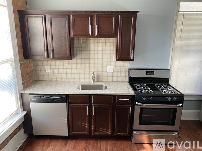 A kitchen with brown cabinets and a stainless steel stove.