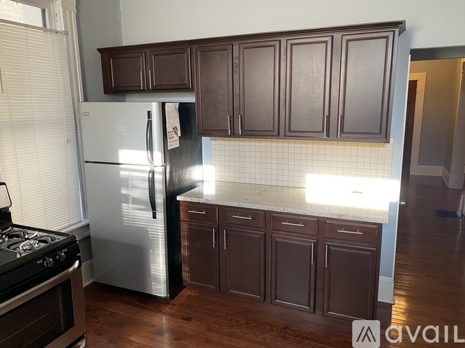 A kitchen with a stove, refrigerator, and cabinets.