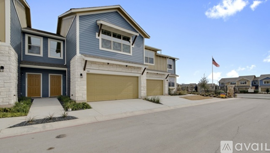 A row of houses with garages and a flag on top.