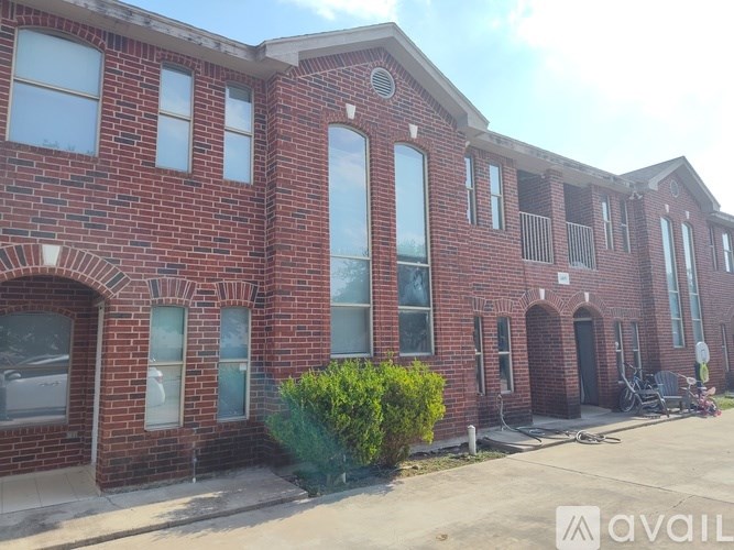 A red brick building with a balcony on the second floor.