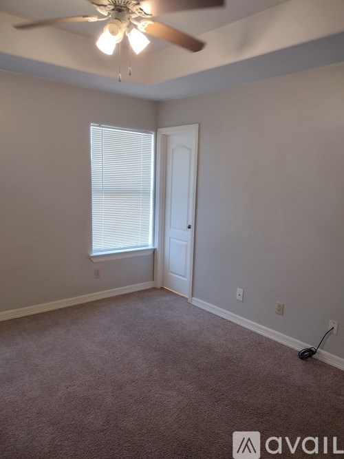 A room with a ceiling fan and a window with blinds.