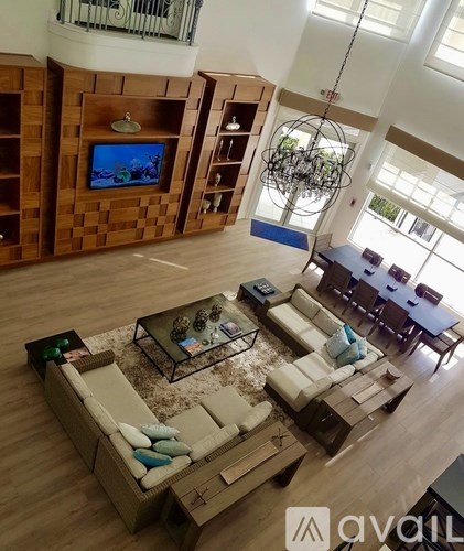 A living room with a television and a glass table.