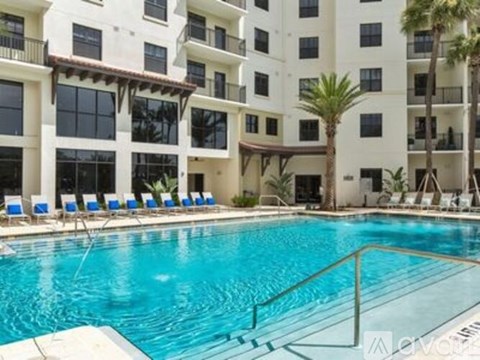 A large swimming pool in front of a white apartment building.