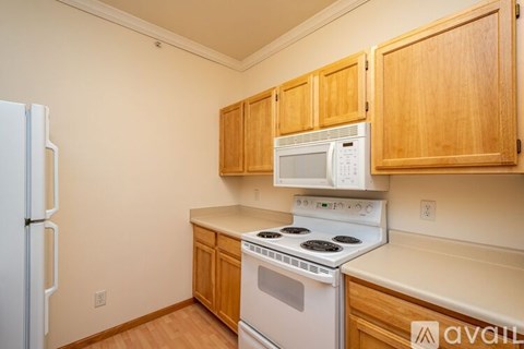 A kitchen with wooden cabinets and white appliances.