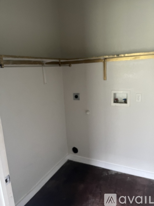 A room with white walls and a white ceiling with a pipe running along it.