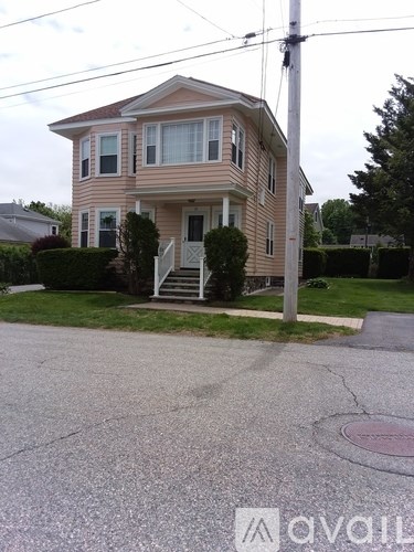 A two-story house with a front porch and a driveway.