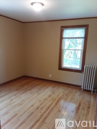 A room with wooden flooring and a window.