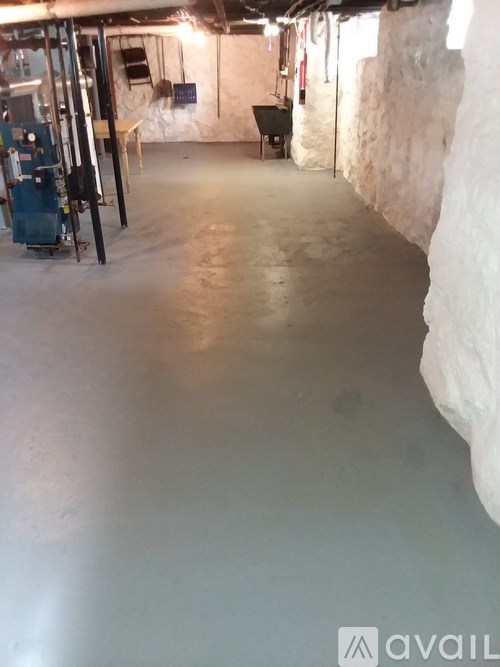 A room with a white wall and a blue machine.