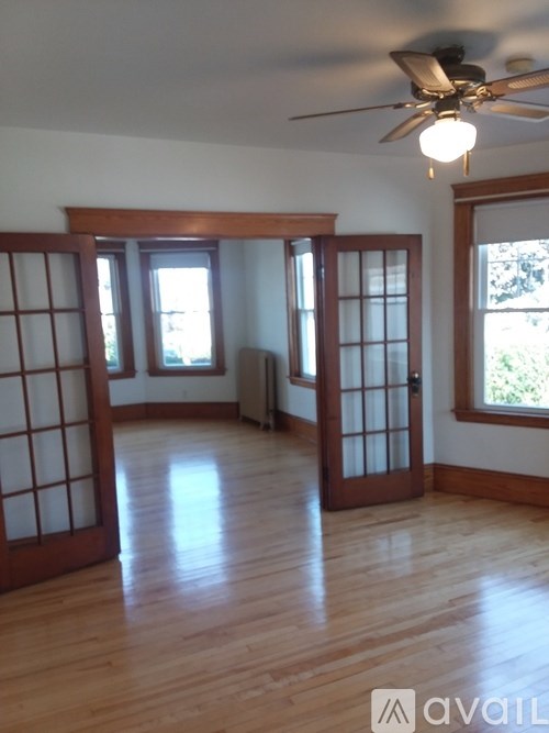 A room with wooden floors and a ceiling fan.