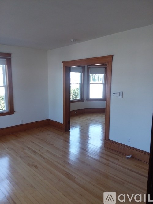 A room with wooden floors and a large mirror on the wall.
