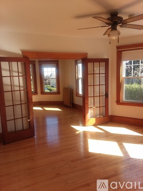 A room with wooden floors and a ceiling fan.