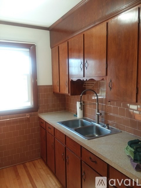 A kitchen with wooden cabinets and a brick wall.