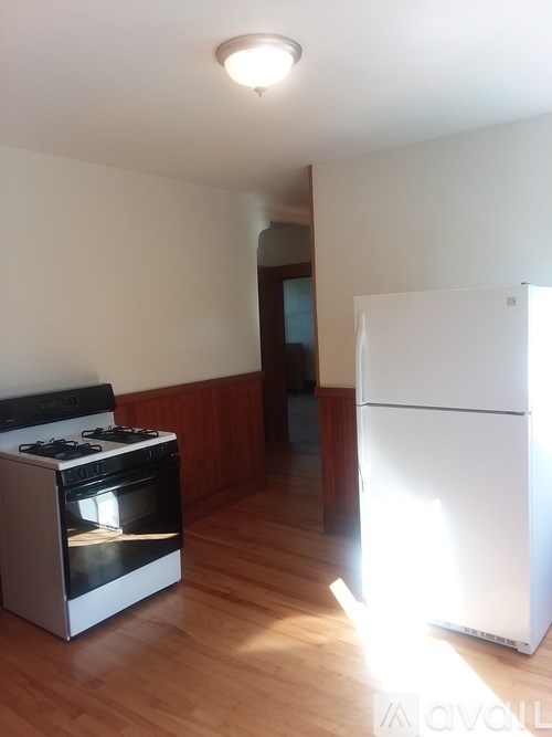 A white fridge in a kitchen with a black stove.
