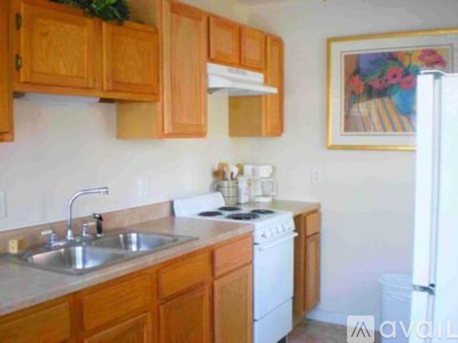 A kitchen with wooden cabinets and a white stove top oven.