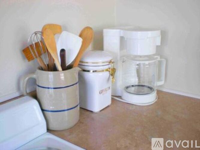 A kitchen counter with a mug, a container, and a blender.